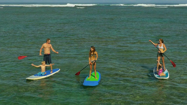 一家人在夏威夷的热带海滩上玩桨视频素材