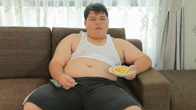 懒惰超重男性坐着吃快餐视频素材