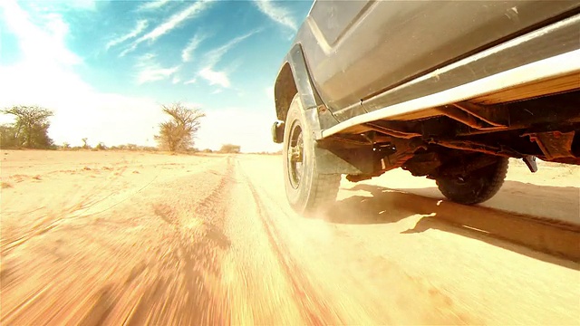 在非洲沙漠的小路上。轮胎上的花纹特写。视频下载