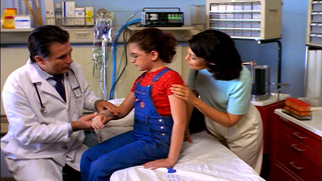 多莉在关切的母亲的注视下拍下了包着工作服女孩手腕的中年男医生视频下载