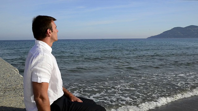 一个人坐在海边。视频素材
