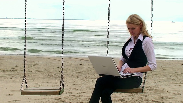 海边带笔记本电脑的美丽女孩视频下载