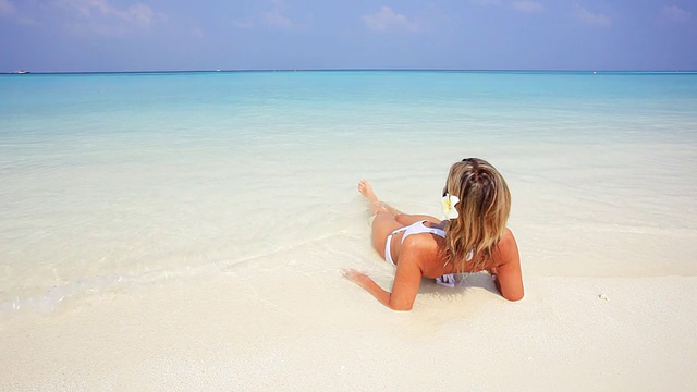 在马尔代夫海滩上放松和日光浴的女人。视频下载