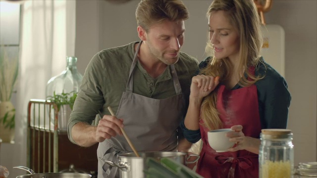 一对夫妇在厨房品尝自制的食物视频下载