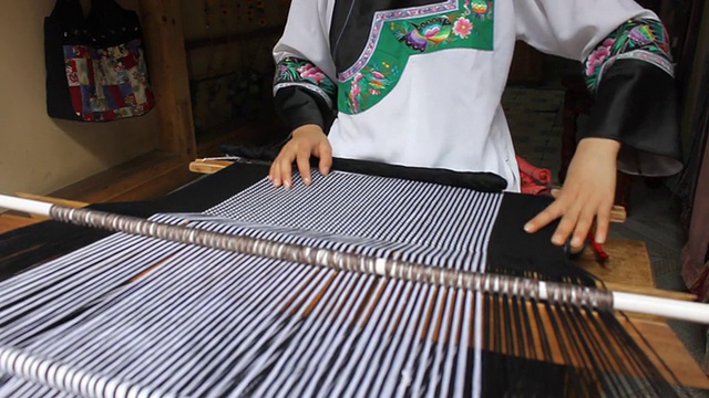 苗族妇女以传统的方法织布视频素材