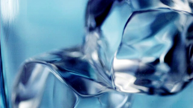 将水倒入加冰块的玻璃杯中。视频素材