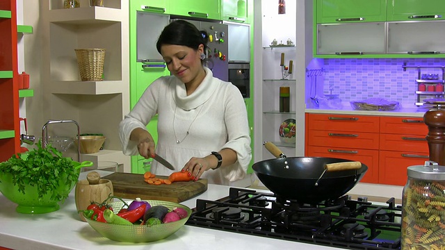 漂亮女孩在厨房切菜视频素材
