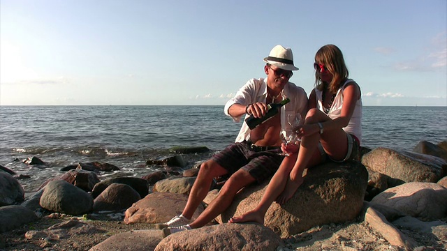 一对情侣在海滩上喝酒视频下载