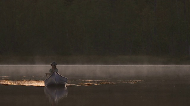 黄昏时分的女子划独木舟视频素材