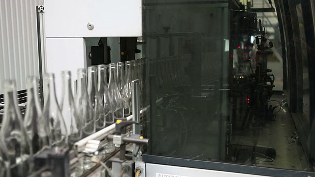玻璃工厂。自动检测瓶子质量的机器。视频素材