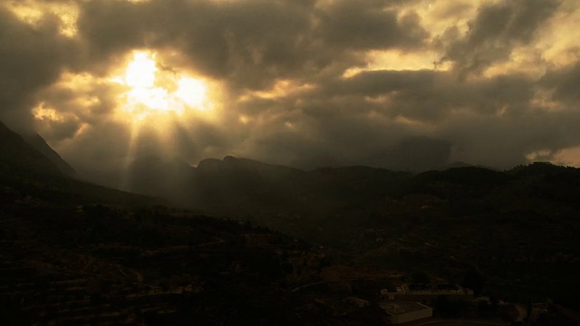 一段时间后的阳光穿过云层越过山脉视频下载