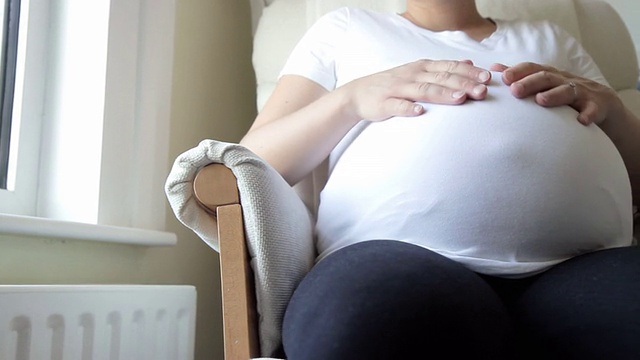 孕妇抚摸着自己的肚子。高清视频素材
