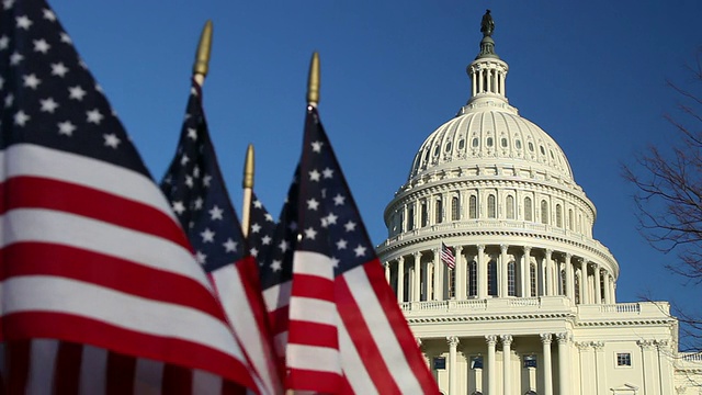 美国国会大厦圆顶，美国国旗在前景- CU视频下载