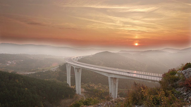日落时分，高架桥上的车流川流不息，雾气弥漫视频下载