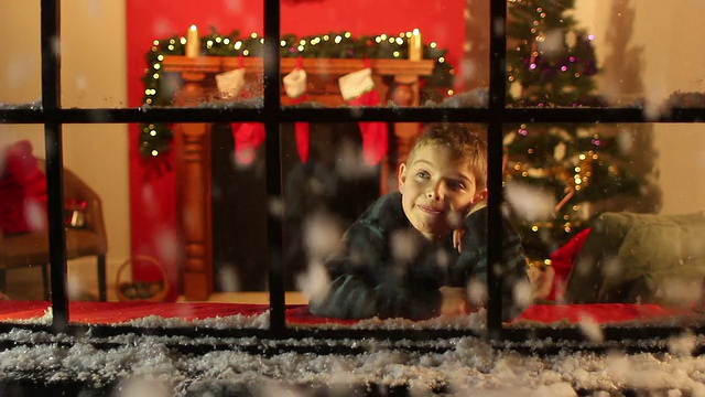 男孩透过窗户看雪-圣诞节视频素材