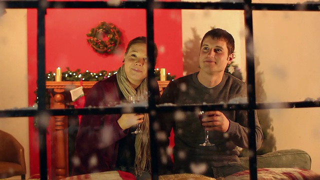 一对夫妇在圣诞窗口喝热红酒视频素材