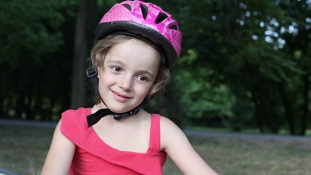 微笑的孩子在户外骑自行车。视频下载