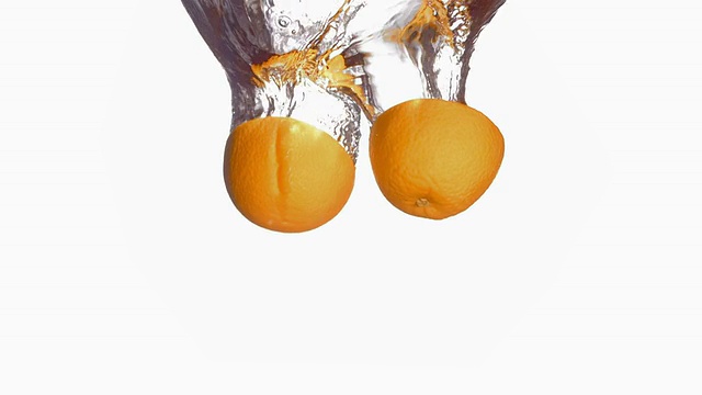 高清超级慢动作:切成一半的橙子溅进水里视频素材