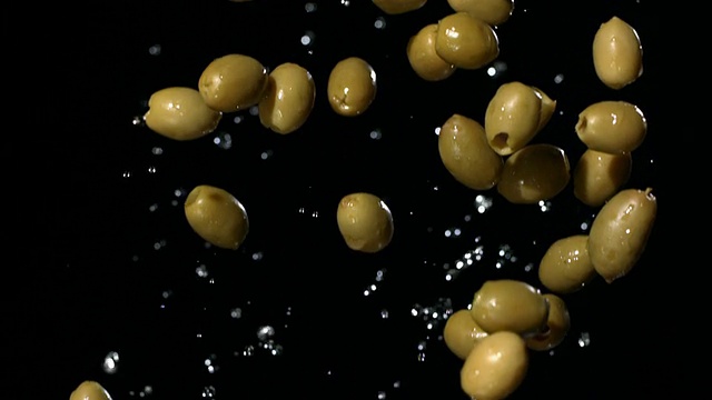 高清超级慢动作:湿橄榄落在黑色背景视频素材