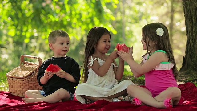 三个孩子一起吃水果视频素材