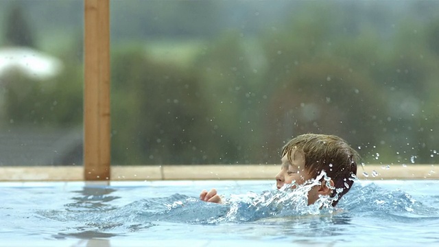 高清超级慢动作:男孩在游泳池里扔球视频素材