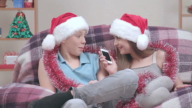 两个戴着圣诞老人帽的年轻人，用免提打电话。视频下载