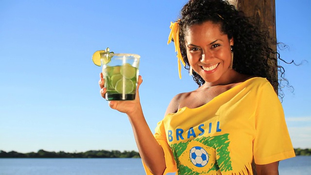 喝凯匹林亚鸡尾酒的巴西女孩视频素材