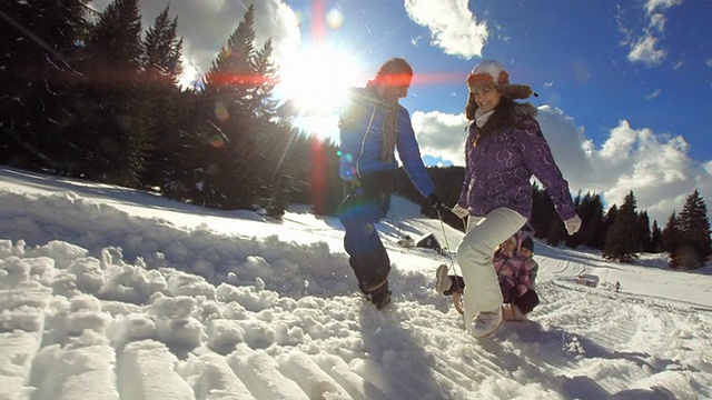 HD超级慢动作:父母拉着孩子上雪橇视频素材
