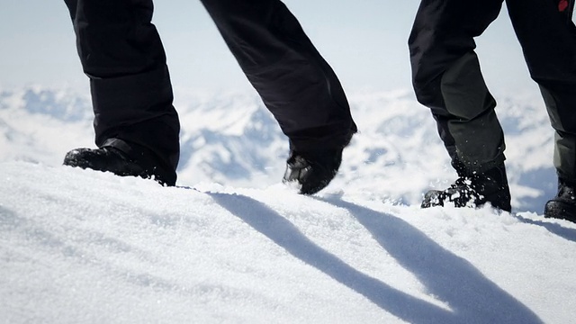 登山者在山上的雪地上行走视频素材