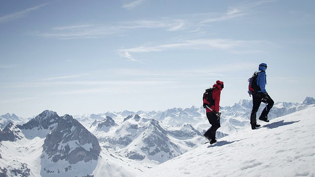 登山者在白雪覆盖的山上行走视频素材