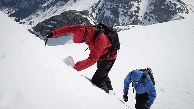登山者爬上白雪覆盖的山视频素材