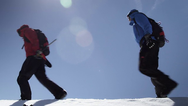 登山者在山上的雪地上行走视频素材