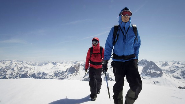 登山者在白雪覆盖的山上行走视频素材