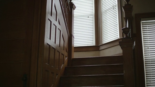 黑暗，空旷，恐怖，室内拍摄，以突袭，令人毛骨悚然的橡木楼梯和护壁板在一个老房子。相机的洋娃娃。视频下载