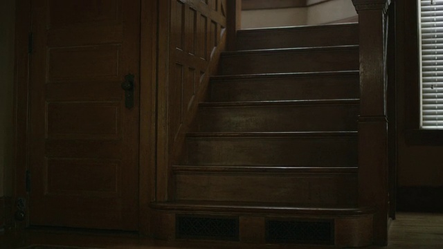 黑暗，空旷，恐怖，室内拍摄，以突袭，令人毛骨悚然的橡木楼梯和护壁板在一个老房子。相机的洋娃娃。视频下载