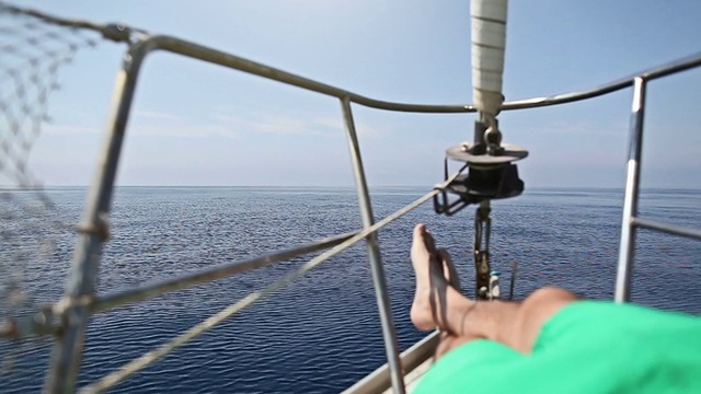 一名男子在帆船上巡游时放松视频素材