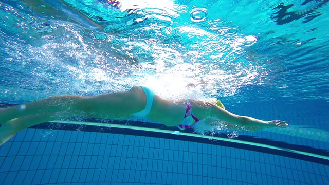 高清超级慢动作水下:年轻女子游泳蛙泳视频素材