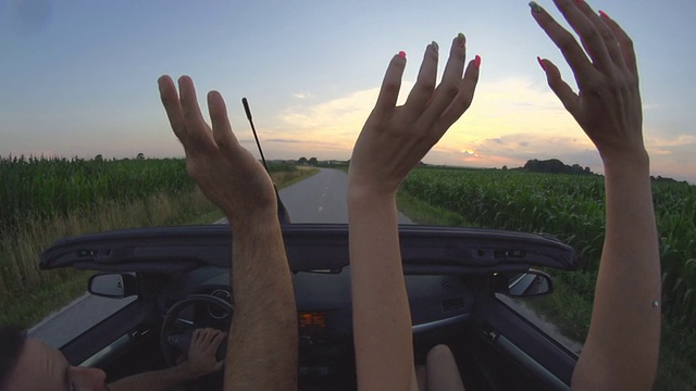 高清慢镜头:一对夫妇在敞篷车里挥手视频素材