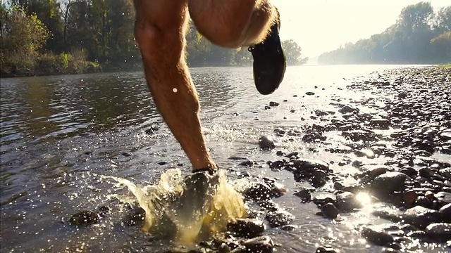 高清超级慢动作:奔跑者在河里溅水视频素材