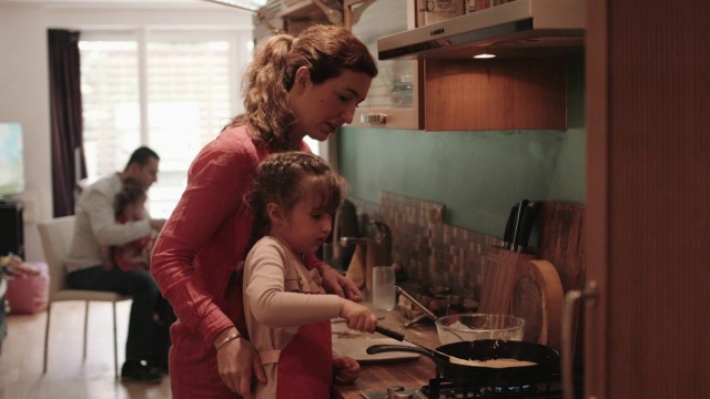 家人在厨房里做煎饼视频素材