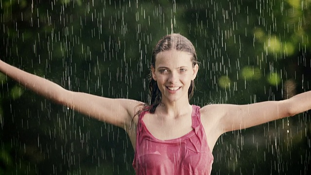 女人喜欢在夏雨中伸展双臂视频素材
