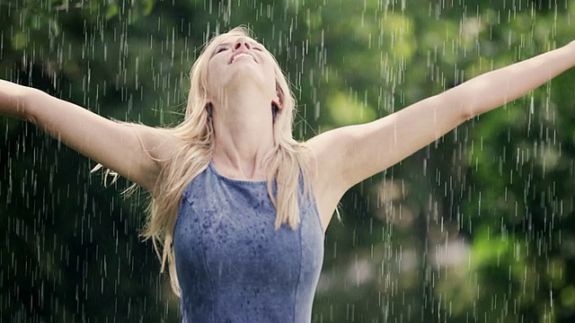 女人在夏雨中纺纱视频素材