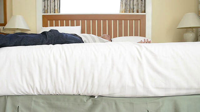 男人平滑一个新的白色床上用品视频素材