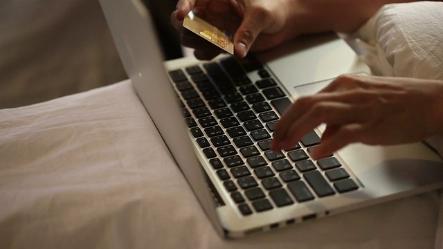 女人用信用卡买东西，用笔记本电脑视频下载