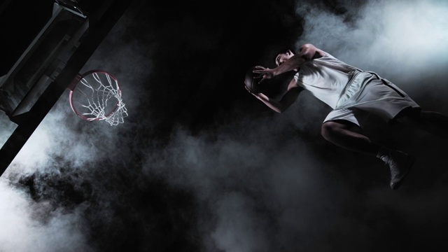 一个篮球运动员表演扣篮的SLO MO视频下载
