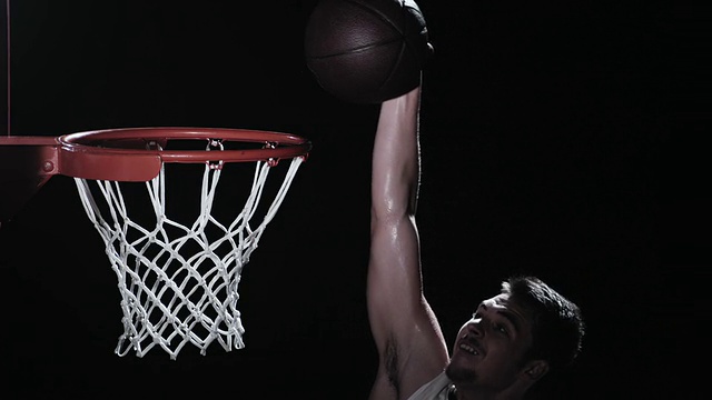 一个篮球运动员表演扣篮的SLO MO镜头视频素材