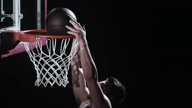 一个篮球运动员把球灌入篮筐的SLO动作视频素材