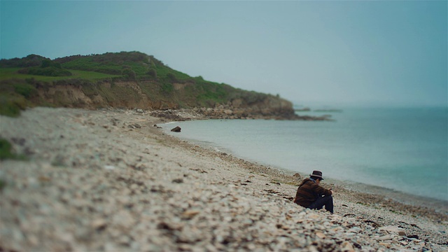 WS，沙滩上的孤独男子，倾斜镜头视频素材