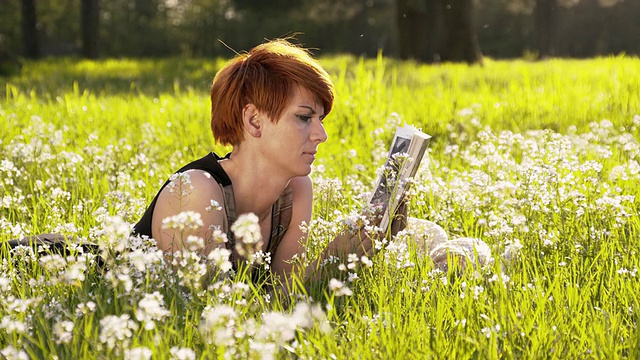 一个在草地上看书的女人视频素材