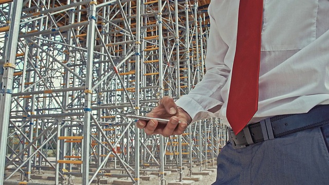 工程师在建筑工地用智能手机视频下载